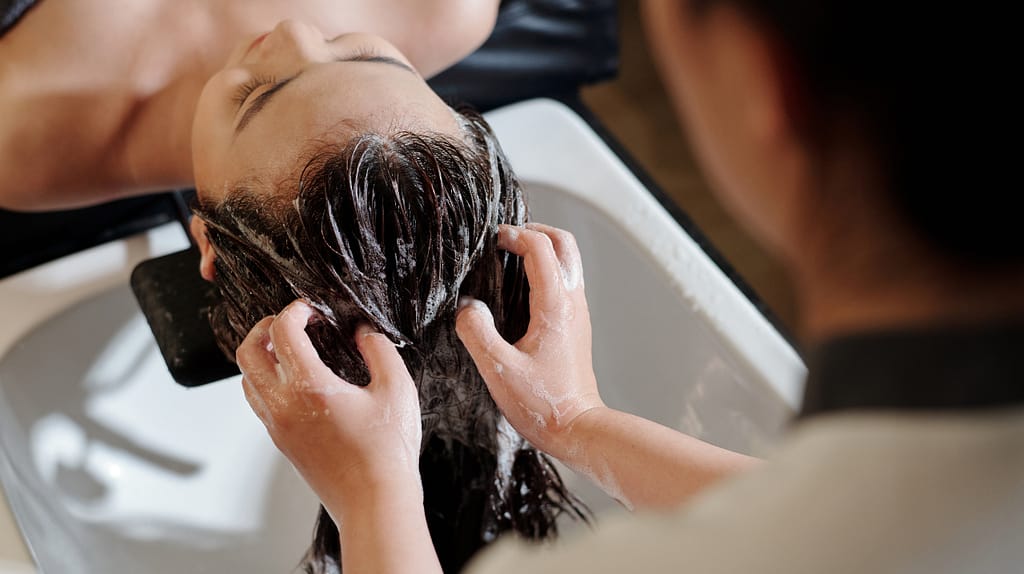Hair being rinsed with lukewarm water after a hair spa treatment